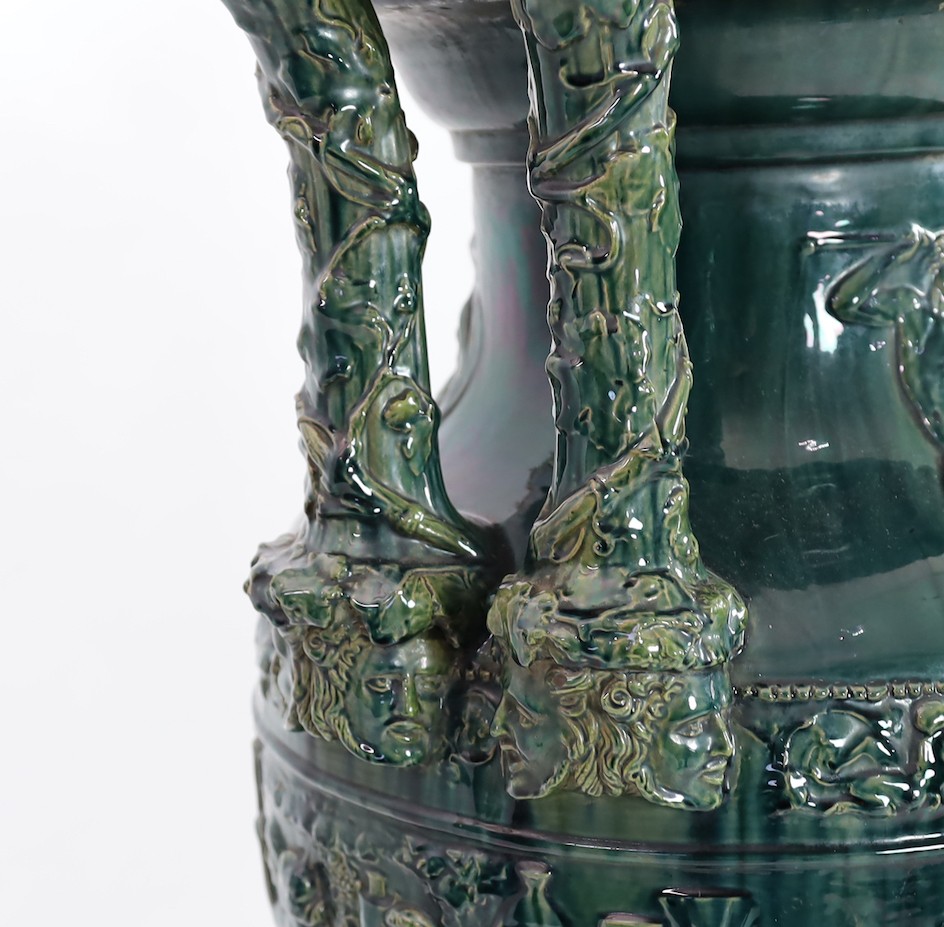 A massive Continental majolica green glazed campana vase and associated stand, late 19th century, total height 153cm, small repairs